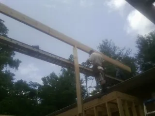 Carpenter setting a ridge beam over a new addition frame — Ice Dam Removal by Roofing Brothers in Casstown