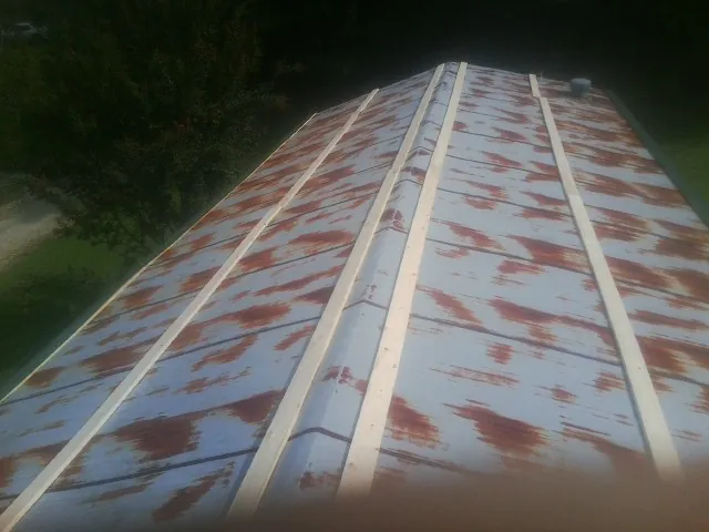 Rusted metal roof panels with new wood purlins before replacement — Storm Damage Roof Repair in Casstown by Roofing Brothers