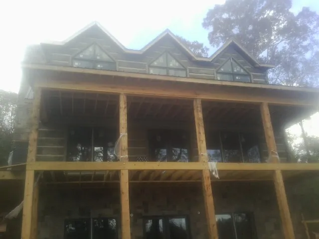 Dormers and porch framing on a large log home under construction — Roof Coating work by our crew in Casstown