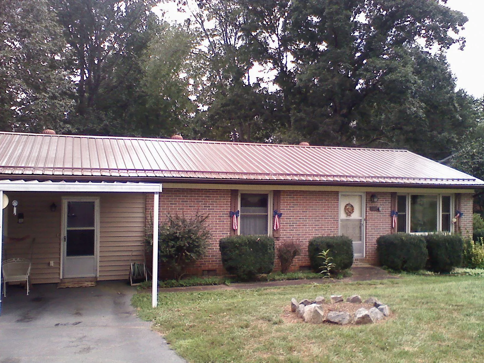 Bronze metal roof and carport on a brick ranch home — Roof Repair work by our crew in Casstown