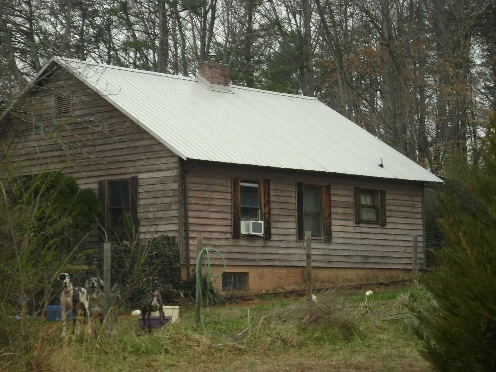 White metal roof on an old wood sided farmhouse, from a Metal Roof Installation job in Casstown